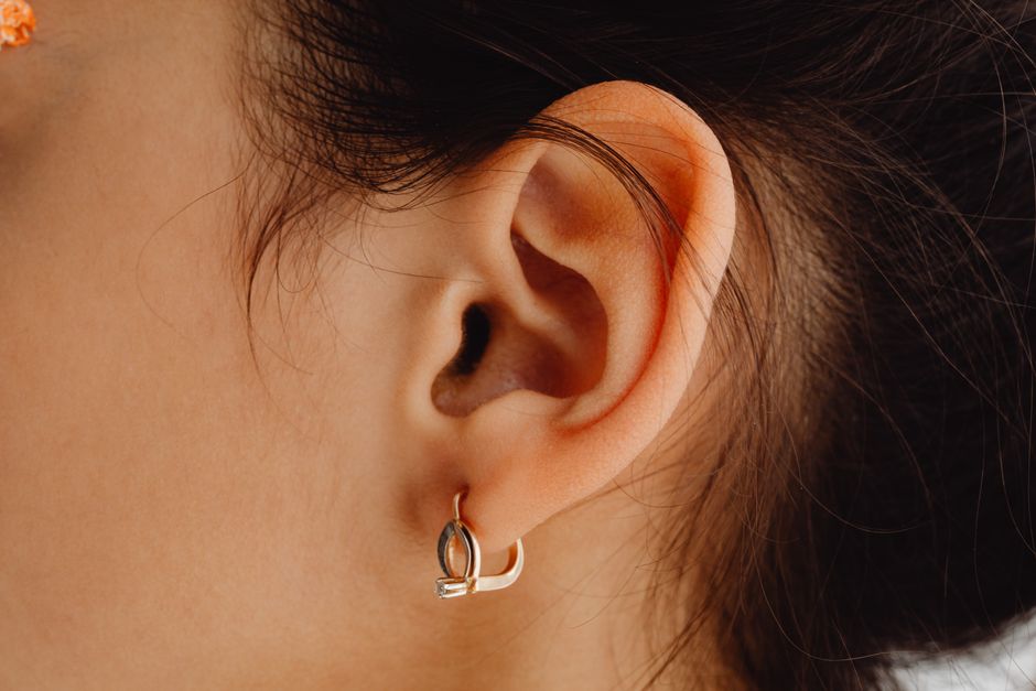 Detailed close-up of a woman's ear adorned with a stylish earring.