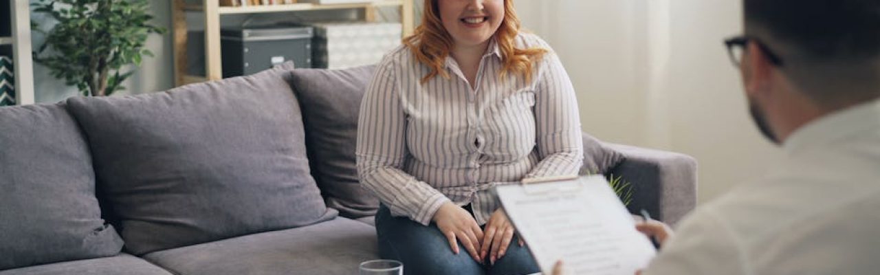 A cheerful woman discussing with her therapist during a consultation in a cozy office setting.