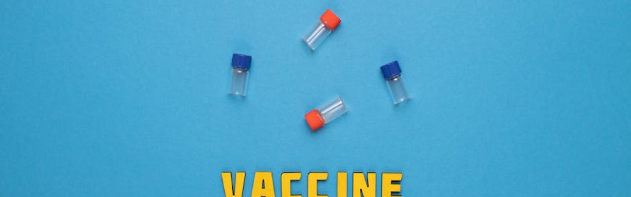 Three small vials and the word 'VACCINE' on a blue background.