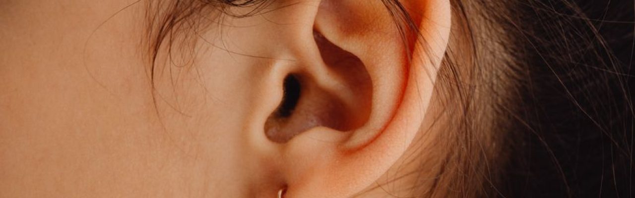 Detailed close-up of a woman's ear adorned with a stylish earring.